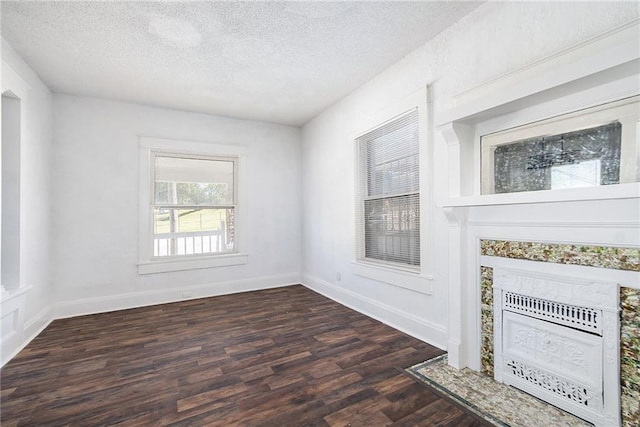 interior space with a fireplace, dark wood-type flooring, a textured ceiling, and baseboards