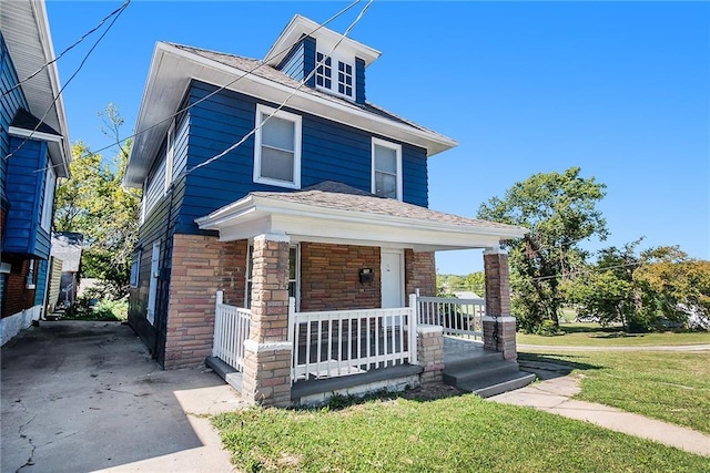 traditional style home with a porch and a front lawn