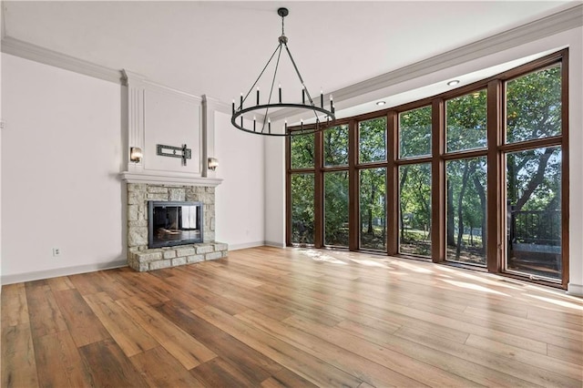 unfurnished living room featuring ornamental molding, a fireplace, a towering ceiling, and light hardwood / wood-style floors