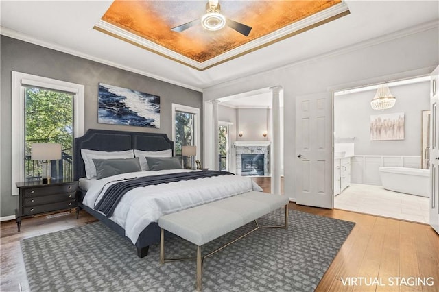 bedroom with ornamental molding, decorative columns, ceiling fan, and hardwood / wood-style flooring