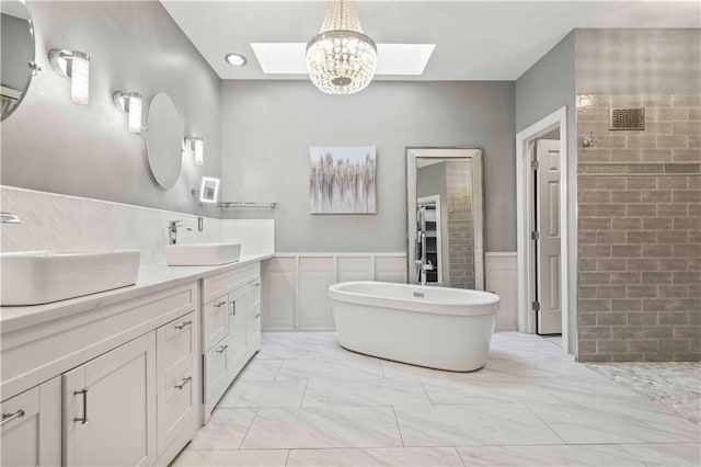 bathroom with tile walls, a chandelier, a skylight, separate shower and tub, and vanity