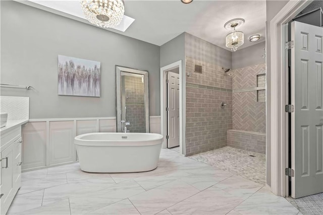 bathroom with vanity, a skylight, and plus walk in shower