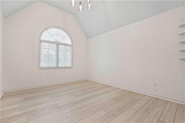 unfurnished room featuring lofted ceiling and light hardwood / wood-style floors