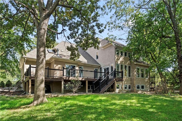 rear view of house with a yard and a wooden deck