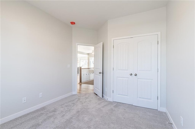 unfurnished bedroom featuring a closet and light colored carpet