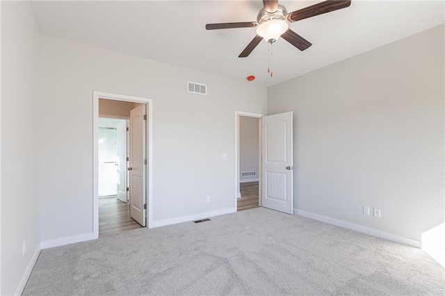 unfurnished bedroom with ceiling fan and light colored carpet