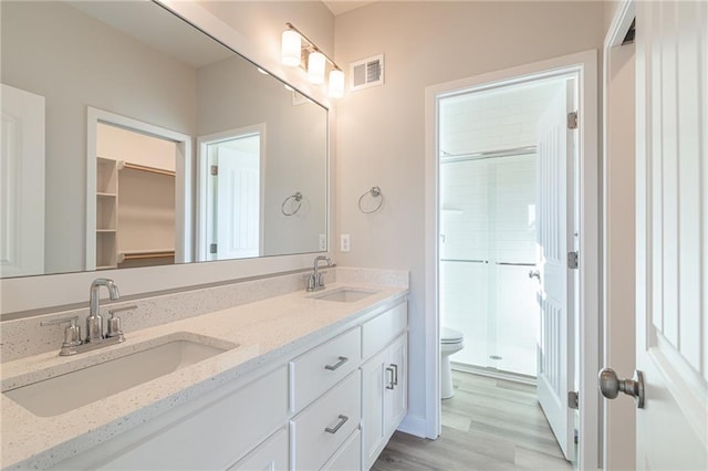 bathroom with vanity, hardwood / wood-style flooring, an enclosed shower, and toilet