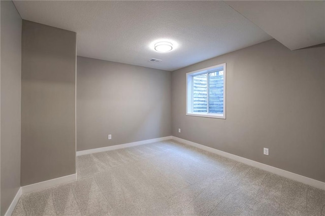 carpeted empty room featuring a textured ceiling