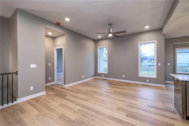 unfurnished living room with a healthy amount of sunlight, ceiling fan, and light hardwood / wood-style flooring