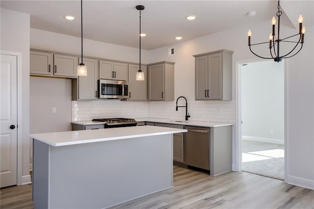 kitchen featuring light hardwood / wood-style flooring, stainless steel appliances, backsplash, and a kitchen island