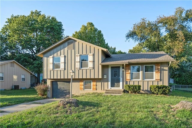 split level home with a front lawn, central air condition unit, and a garage