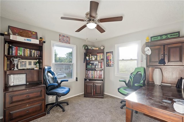 carpeted home office featuring ceiling fan