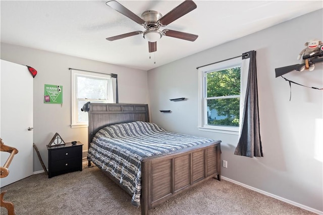 carpeted bedroom featuring ceiling fan and multiple windows