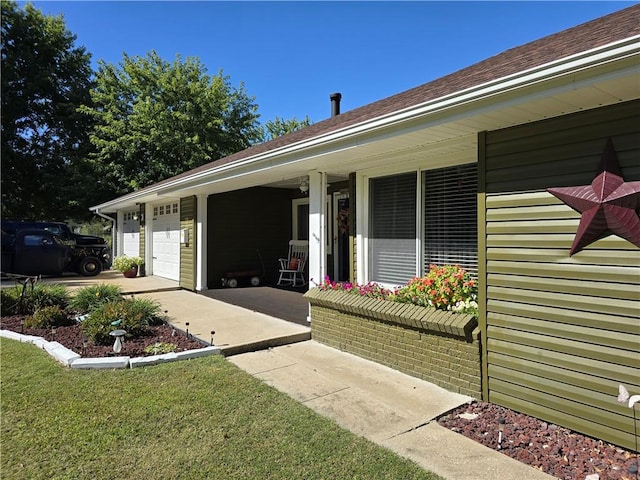 exterior space with a yard, a porch, and a garage