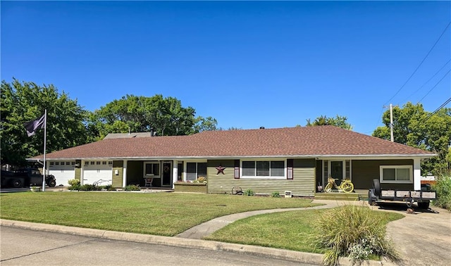 single story home featuring covered porch, a front yard, and a garage