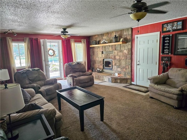 living room with ceiling fan, light colored carpet, a textured ceiling, and a stone fireplace