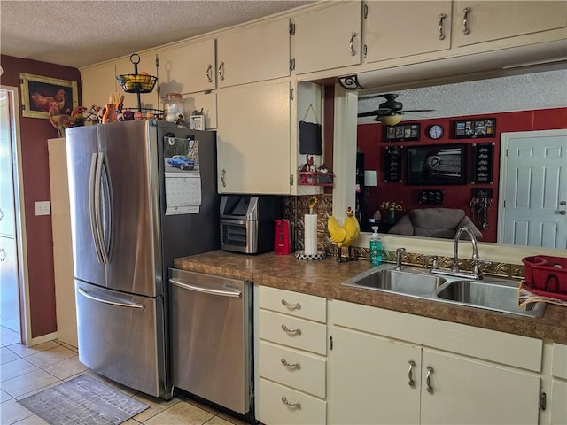 kitchen featuring ceiling fan, sink, light tile patterned floors, a textured ceiling, and appliances with stainless steel finishes