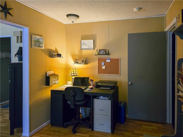 office with a textured ceiling, wood walls, and dark wood-type flooring