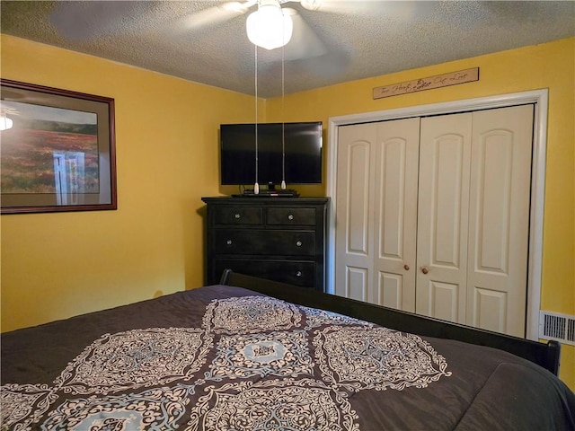 bedroom featuring a textured ceiling, ceiling fan, and a closet