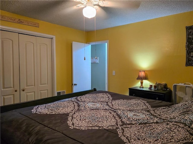 bedroom with a textured ceiling, ceiling fan, and a closet