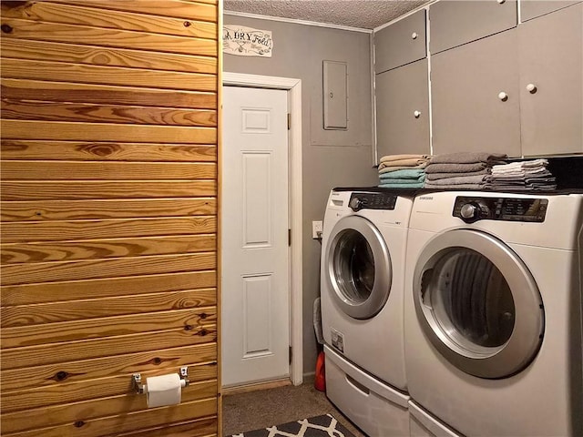 washroom featuring a textured ceiling, washing machine and dryer, and cabinets