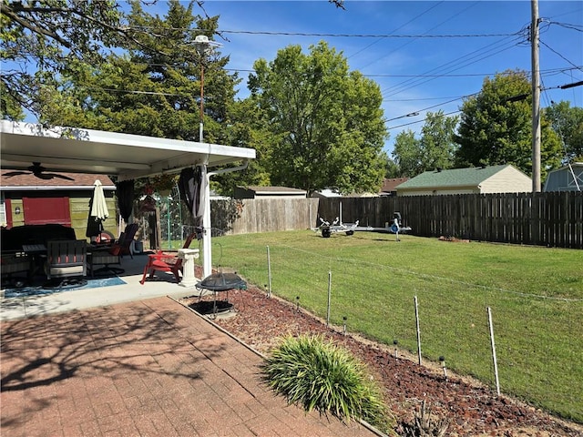 view of yard with a patio, ceiling fan, and an outdoor fire pit