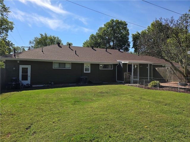 back of house featuring a lawn and central AC