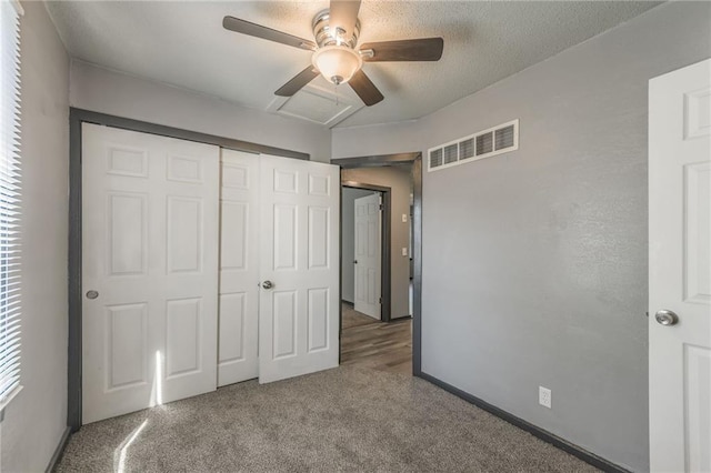 unfurnished bedroom featuring a closet, multiple windows, carpet flooring, and ceiling fan