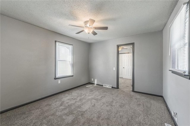 carpeted empty room featuring a textured ceiling and ceiling fan