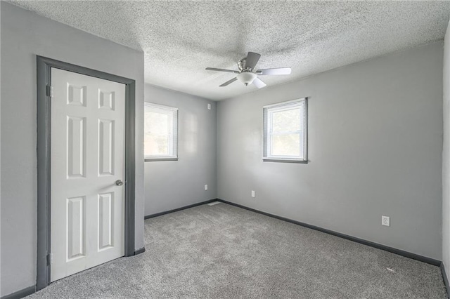 unfurnished bedroom featuring ceiling fan, a textured ceiling, and multiple windows