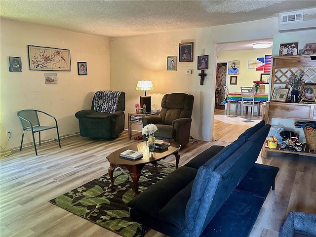 living room featuring a textured ceiling and wood-type flooring