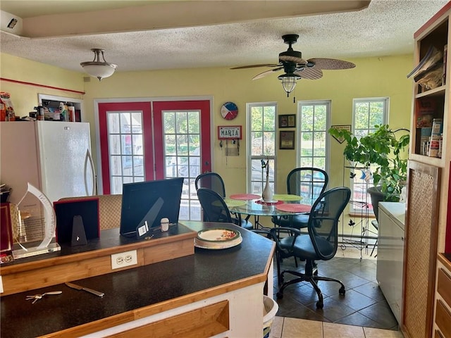 office space featuring tile patterned flooring, ceiling fan, and a textured ceiling