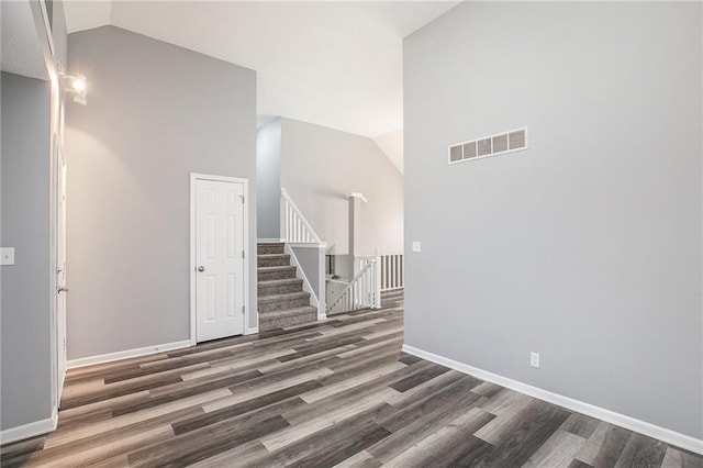 interior space with dark hardwood / wood-style floors and high vaulted ceiling