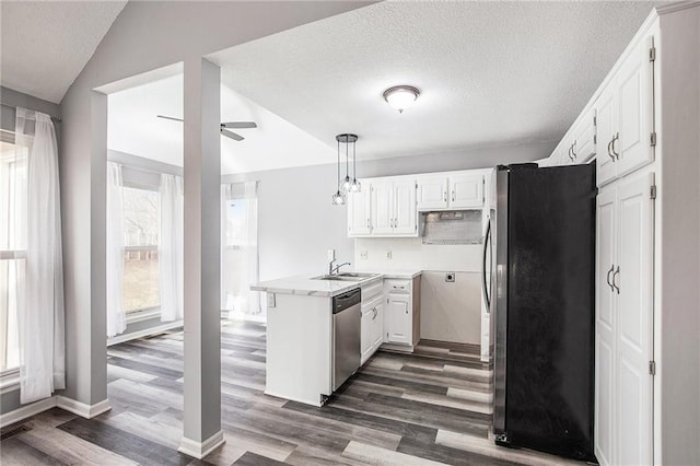 kitchen with kitchen peninsula, decorative light fixtures, lofted ceiling, white cabinets, and appliances with stainless steel finishes