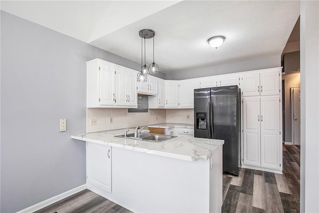 kitchen featuring kitchen peninsula, sink, white cabinetry, and fridge with ice dispenser