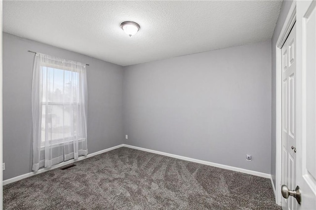 empty room featuring carpet flooring and a textured ceiling