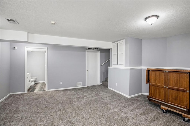 basement featuring carpet floors and a textured ceiling