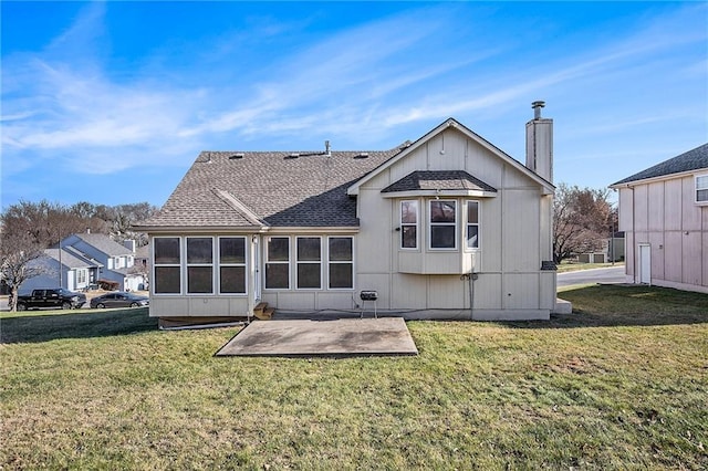 rear view of property with a yard and a patio area