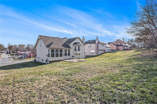 rear view of property with a lawn