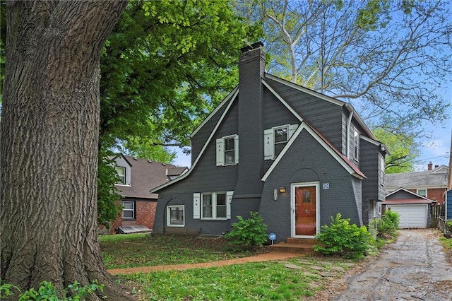 507 E 75th St, Kansas City, MO 64131 - view of front of house featuring a chimney, brick siding, and an outbuilding