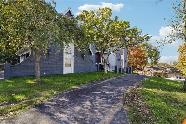 view of front facade with brick siding and a front yard