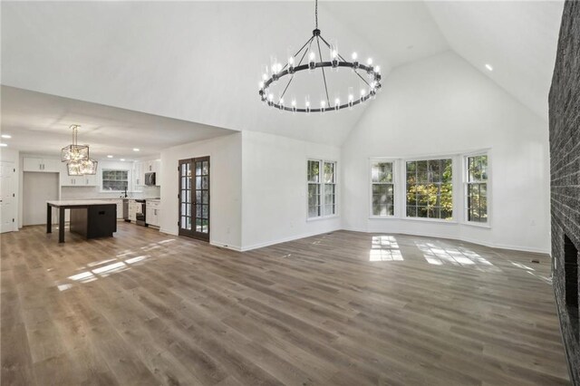 unfurnished living room with a brick fireplace, dark hardwood / wood-style floors, and high vaulted ceiling