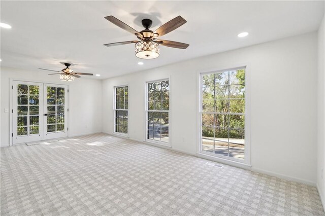 unfurnished room featuring french doors, light carpet, and ceiling fan