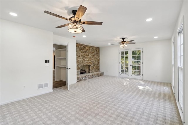 unfurnished living room with light carpet, a fireplace, and ceiling fan