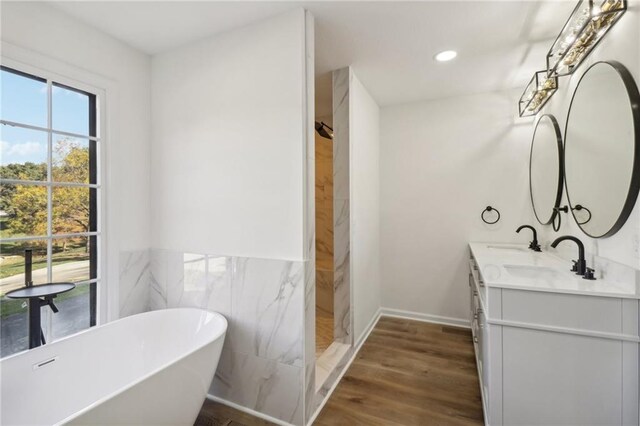 bathroom featuring vanity, tile walls, independent shower and bath, and hardwood / wood-style floors