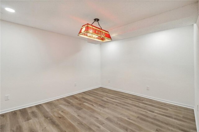 spare room with recessed lighting, wood finished floors, and baseboards