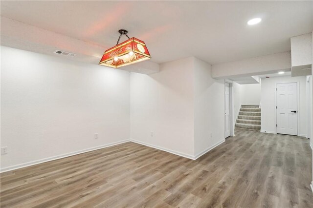 unfurnished room with recessed lighting, visible vents, wood finished floors, and baseboards