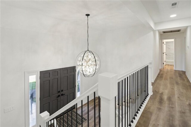 entryway with a notable chandelier and wood-type flooring