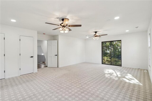 unfurnished room featuring light colored carpet and ceiling fan