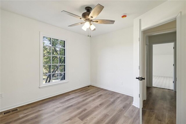 unfurnished room with light wood-type flooring and ceiling fan